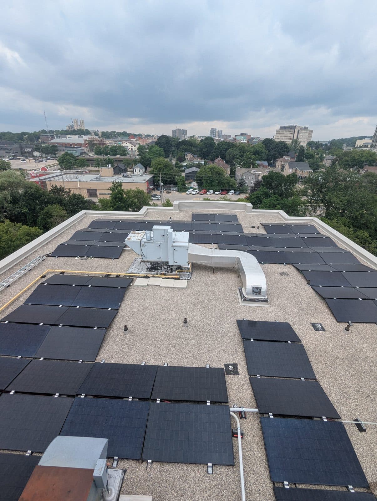 Rooftop solar array at 85 Neeve Street in Guelph with the city behind