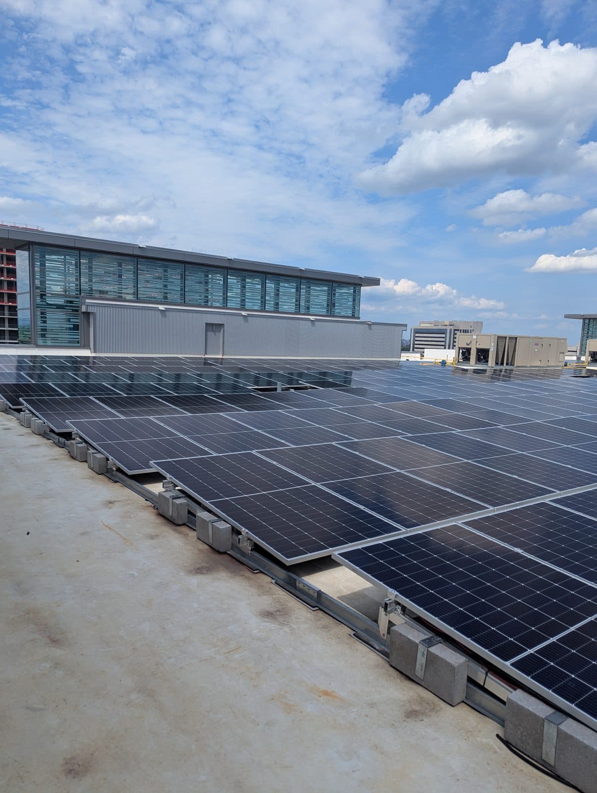 Ballasted rooftop solar array beside a modern commercial building