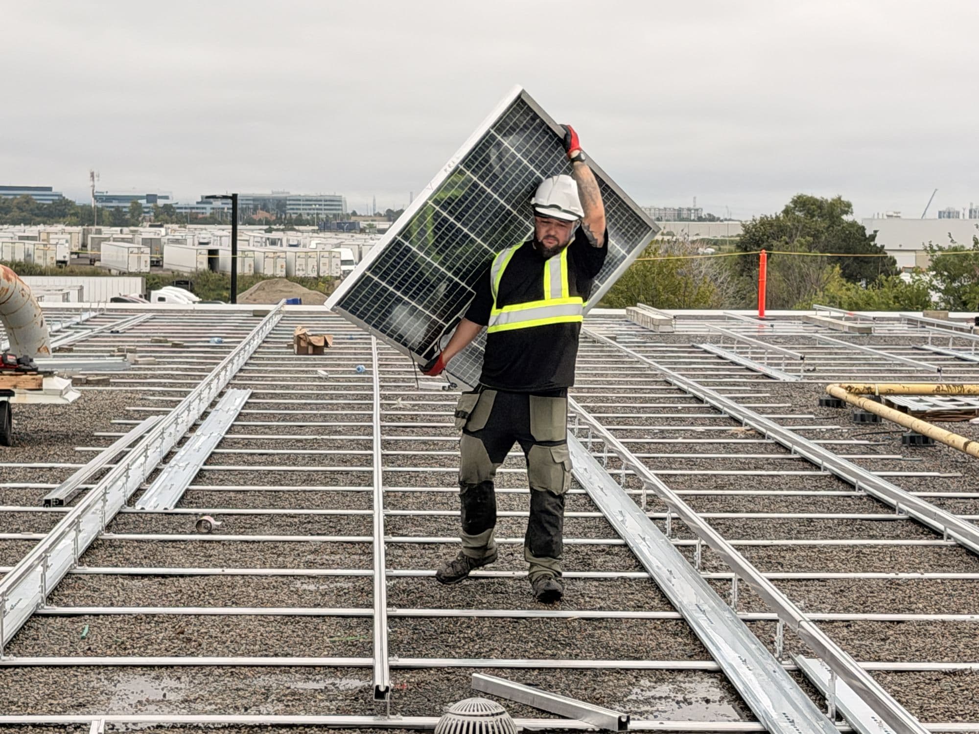 Tero Power installer carrying a solar module on a rooftop in Mississauga