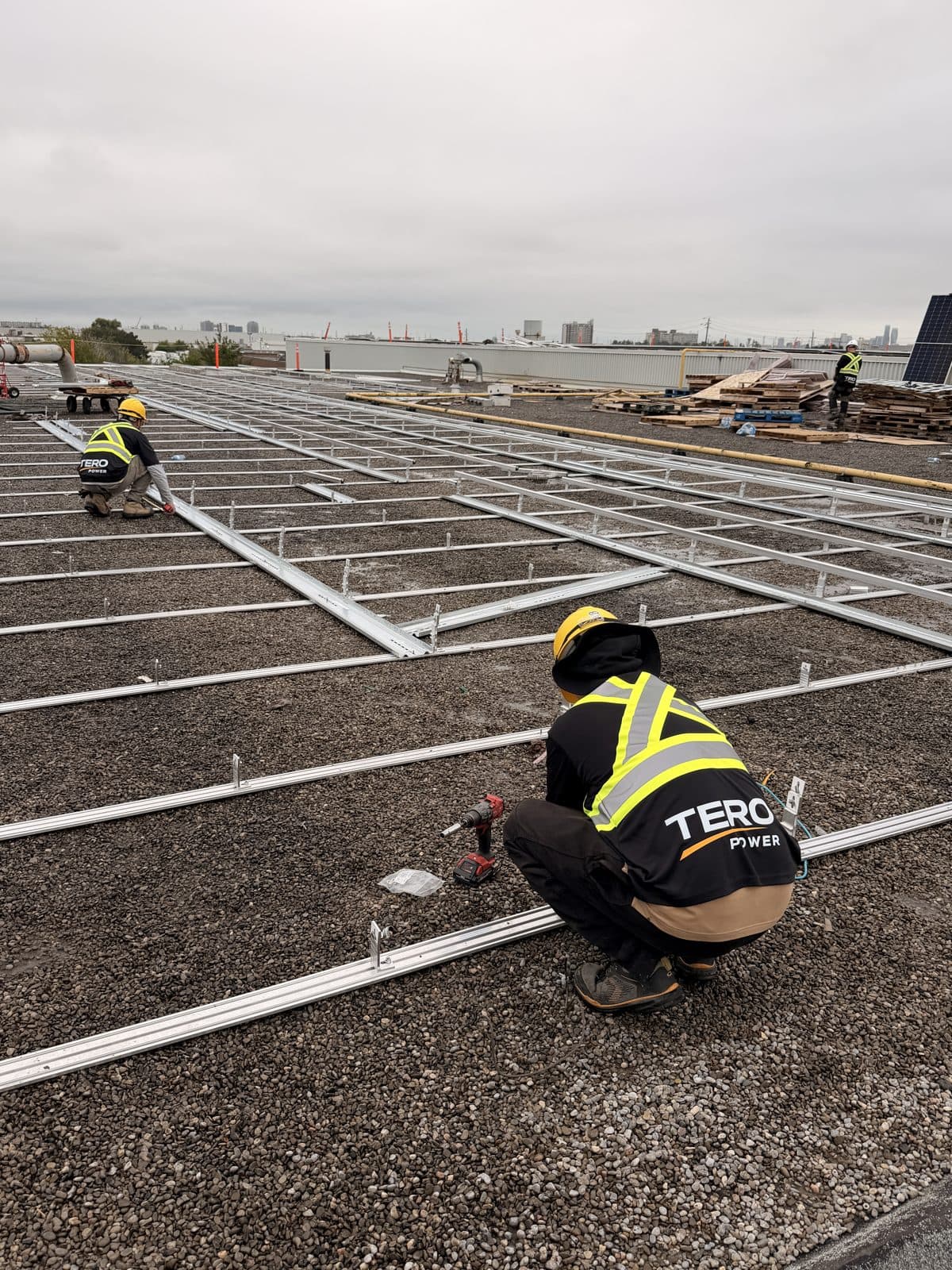 Tero Power installers fastening ballasted racking on a packaging plant roof in Mississauga